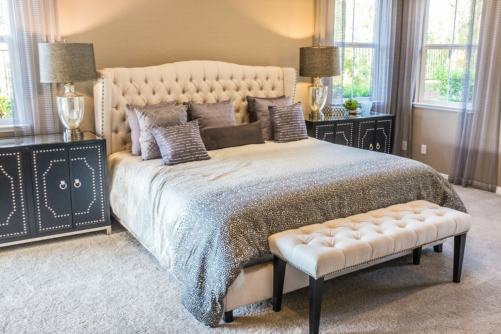 King Suite — bedroom with tufted headboard and sitting bench